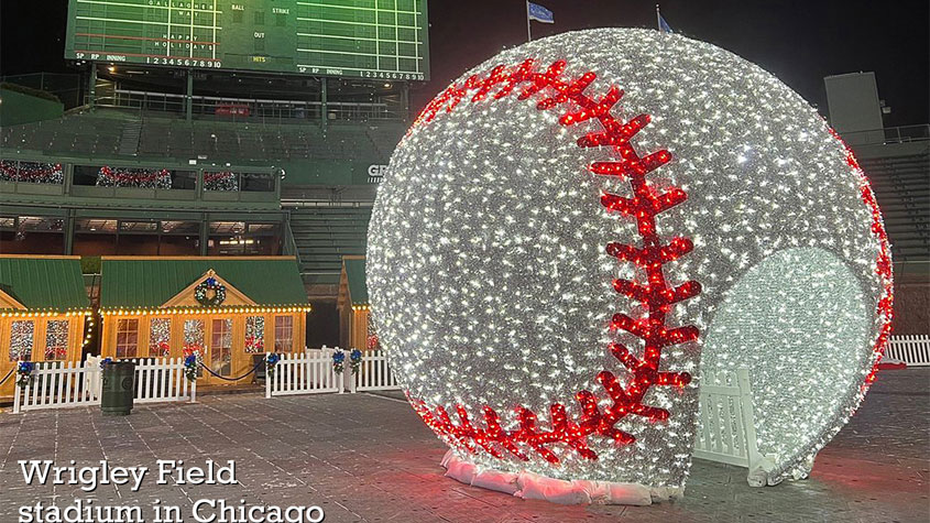 Photo of a large walk through baseball, covered in white lights with red lights to represent the stitching on the ball