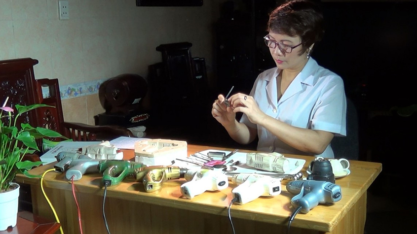 Pham Thi Chan, founder and head of Khanh Thien Pharmaceuticals at a desk with several moxibustion blowers