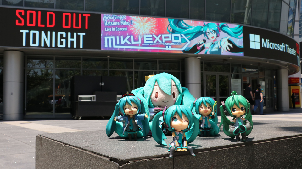 Photo of five Hatsune Miku merchanise dolls outside a concert venue