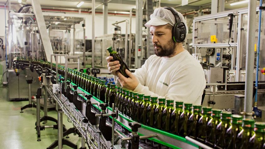 Photo of a Muela Olives staff member checking the production line