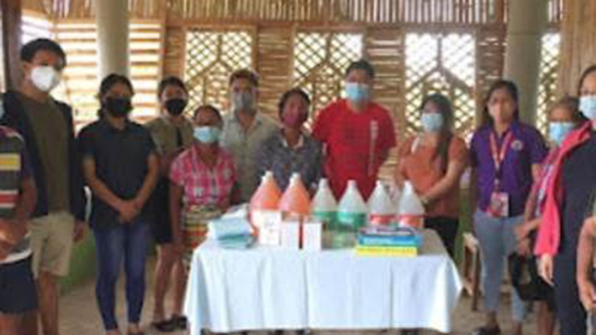 A group of people with masks on around a table full of medical equipment