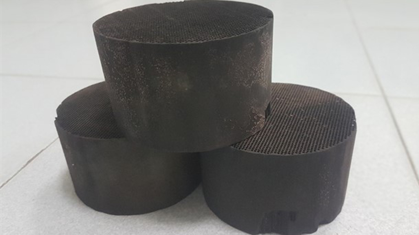 Three catalytic converter filters in the form of black cylinders with a perforated surface