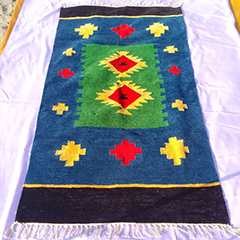 A Shataranji carpet with a brightly colored geometrical design: blue, yellow, green and red