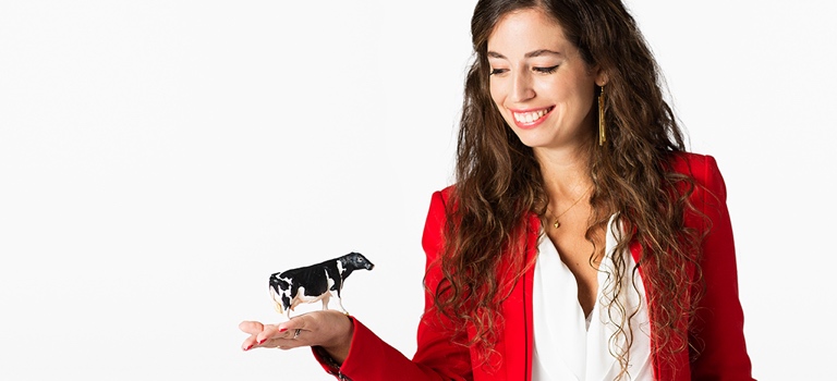 Victoria Alonsopérez, founder of Chipsafer, is holding a scale model of a cow