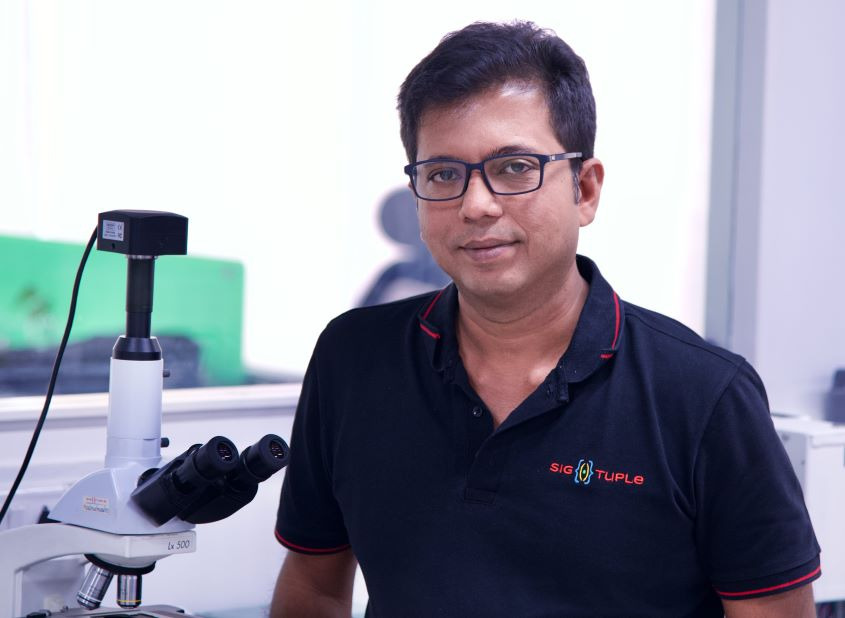 Tathagato Rai Dastidar Co-Founder of SigTuple in front of a microscope