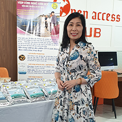 Hà standing next to a table where her products are displayed during an event on women innovators and IP in Hanoi