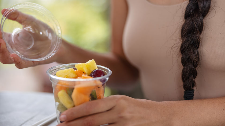 Close Up Of A Woman Holding A Fruit Salad