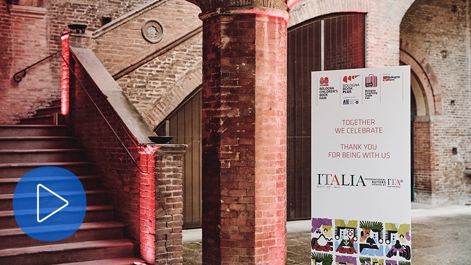 Video thumbnail showing a historic brick interior with a staircase and an event sign thanking attendees at the Bologna Children’s Book Fair.