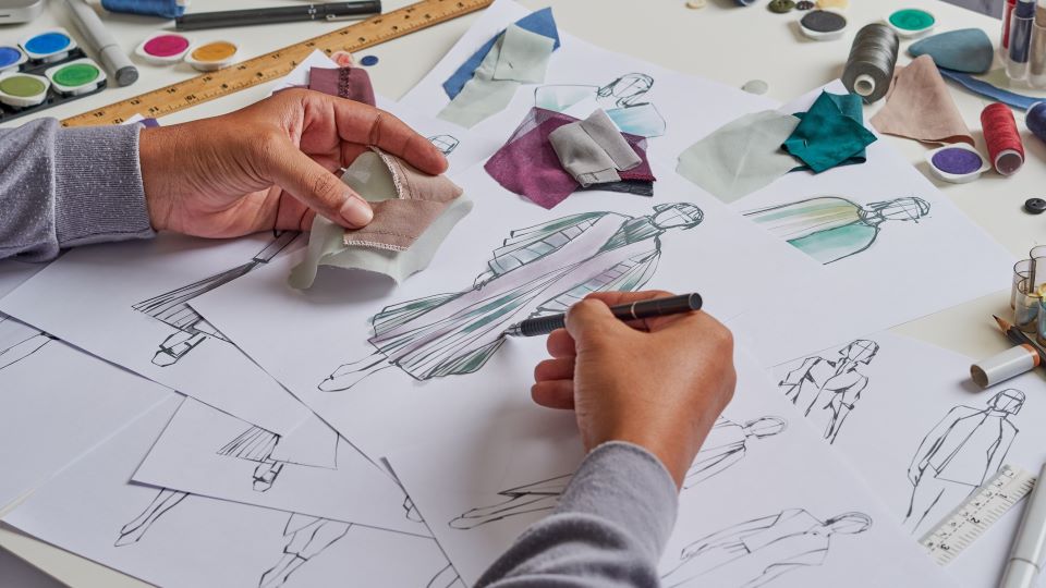 Styliste en train de dessiner un vêtement pour femmes.