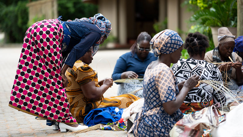 Photo of a master weaver teaching participants in a practical session