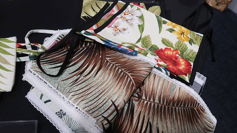 Several colorful pouches featuring coconut leaves and flowers on a table
