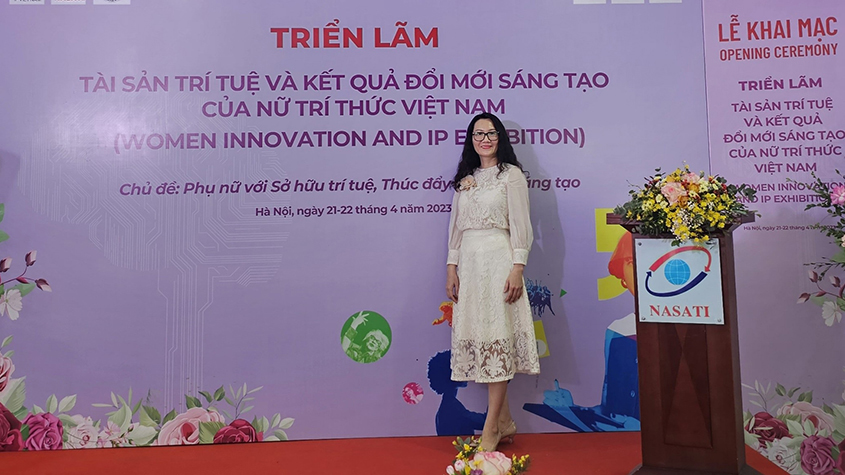 Ly Hua Thi Lan Phuong, owner of Chân Phương, standing in a white dress in front of an event banner
