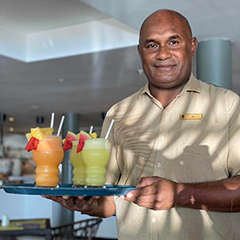A waiter serving Piñacoladas and Daiquiri cocktails made with CocoPine juices