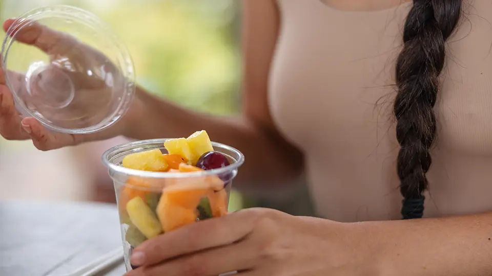 Close Up Of A Woman Holding A Fruit Salad
