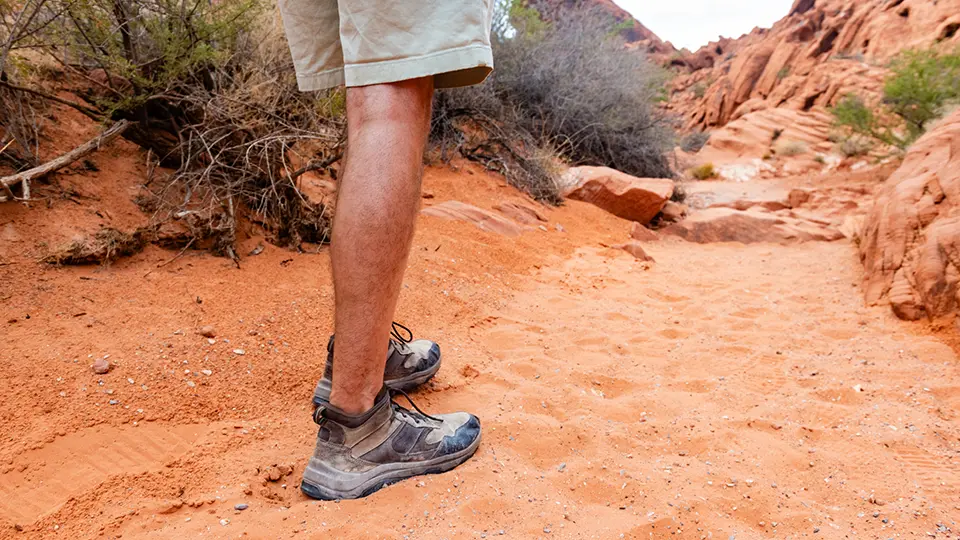 A man hiking on a sandy trail in the scenic desert landscape