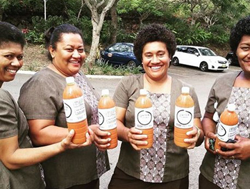 A group of four Fijian women holding bottles of Juice Fiji