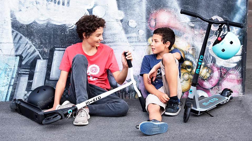 Two teenagers with their Micro Mobility skatepark scooters