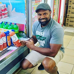 Panapasa Daunakamakama, founder and owner of Juice Fiji holding a bottle of Juice Fiji