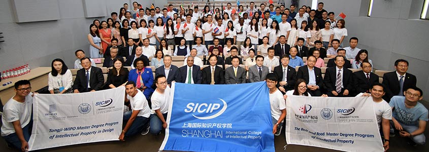 Participants in the program pose with banners for a group photo.