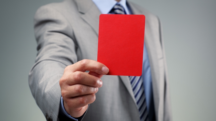 бизнесмен, показывающий красную карточку, как концептуальное представление арбитража в области интеллектуальной собственности в спорте