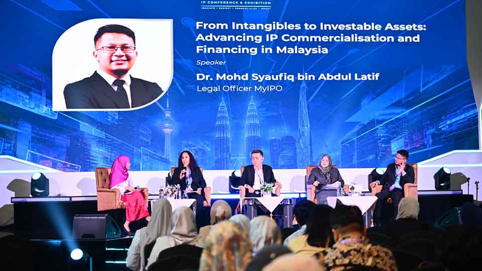 Five panelists seated on stage at an IP conference beneath a screen reading: From Intangibles to Investable Assets