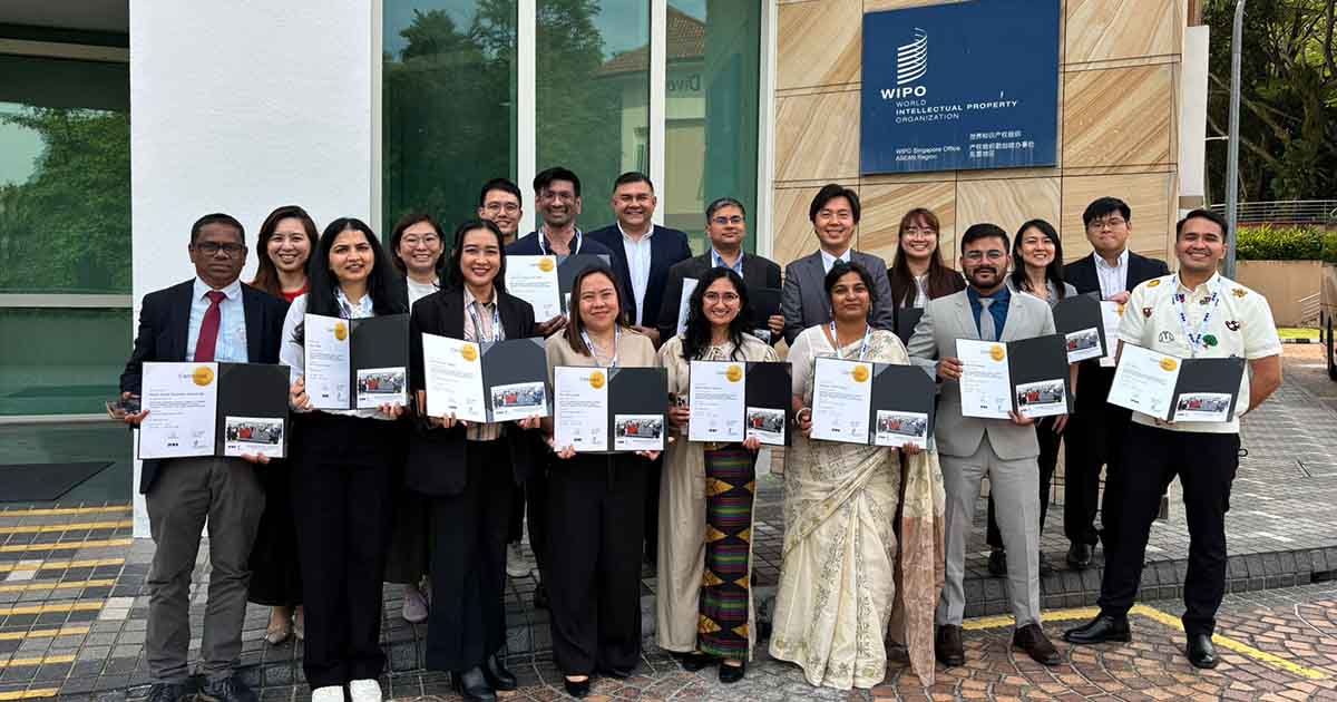 A diverse group of approximately 17 professionals pose together outside the WIPO Singapore Office, ASEAN Region