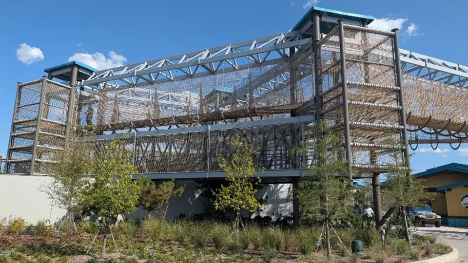 Multi-level enclosed ropes course with netted climbing elements.