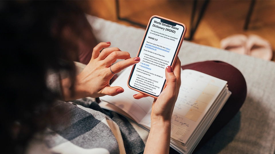 Woman consulting the World Gender Name Dictionary on mobile