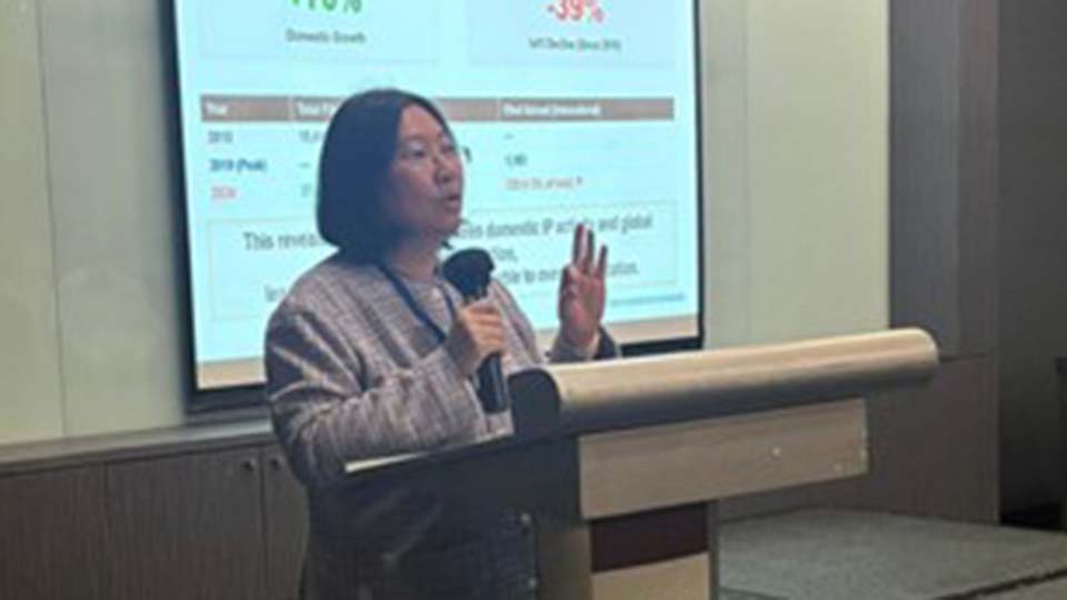 A speaker presents at an SMX podium with a slide showing Trademark Filing Trends (2015–2024) projected behind her.