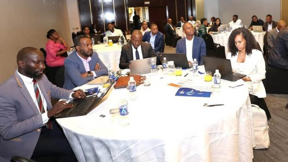 Business professionals working on laptops at round tables during a conference session