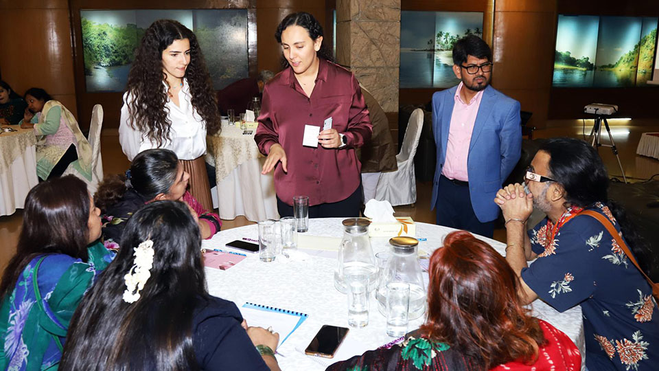 Facilitator leading a small group discussion at a round table during a workshop