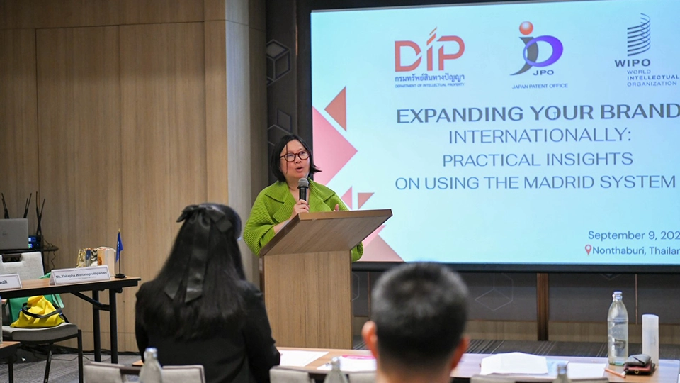 Woman speaking at a podium, with a screen behind her titled Expanding Your Brand Internationally: Practical Insights on Using the Madrid System, dated September 9, 2026, in Nonthaburi, Thailand.