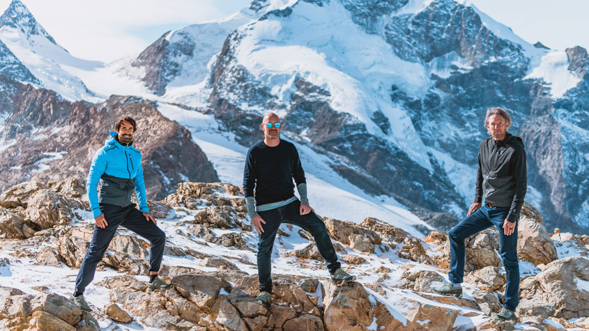 Fotografía de los tres cofundadores de On en una montaña nevada, con zapatillas de On