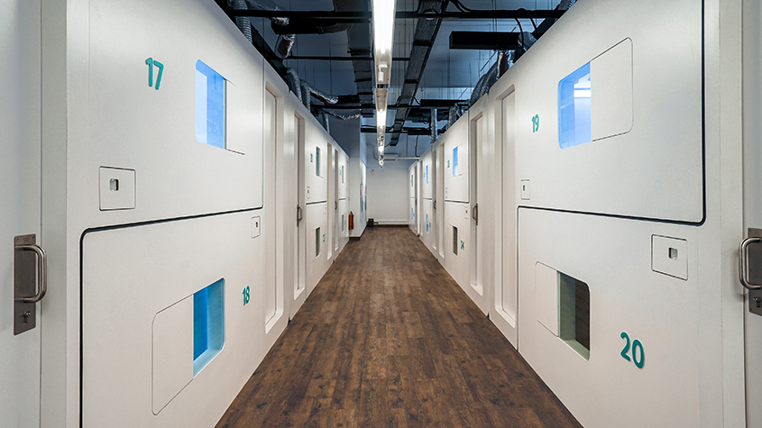 A corridor with on each side a row of Bobobox capsules