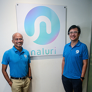 Naluri’s co-founders Azran Osman-Rani and Dr. Jeremy Ting standing in front of a Naluri logo poster