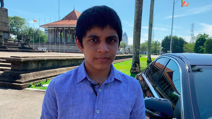 Nimsath, the 13 years old founder of Marspreneurs, next to a car