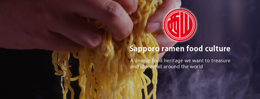 Two hands grabbing noodles. Caption in image reads: Sapporo ramen food culture. A unique food heritage we want to treasure and spread all around the world.
