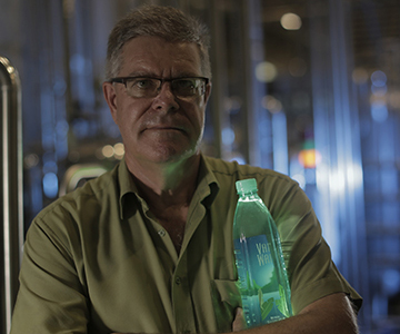 Warrick Pleass, CEO of Pleass Global, holding a bottle of VaiWai® water