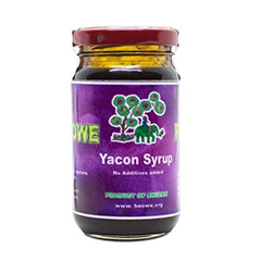A jar of yacon syrup with a purple label featuring a green tree and a green elephant