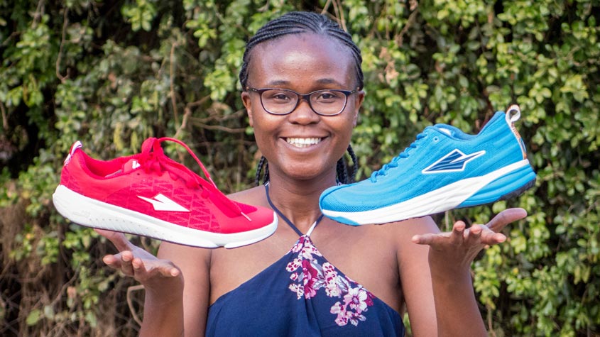 kenyan female entrepreneur showing two sport shoes that her company produces