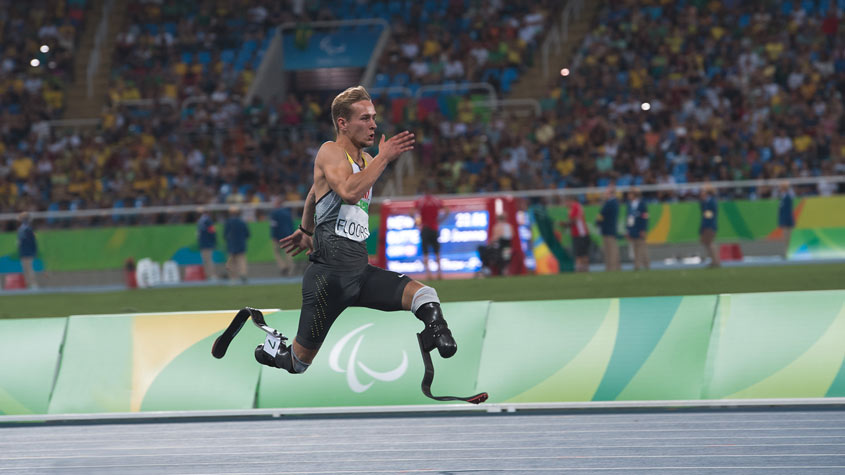 一位男性残奥会运动员使用假肢奔跑，标志着创新改善所有人参与体育运动的方式