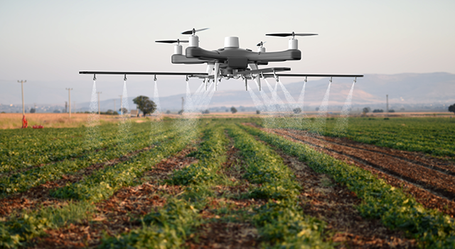 Drone spraying a field - stock photo