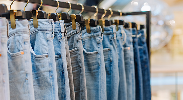 tylish jeans pants in a clothing store on the stands showcase with labels for the inscription