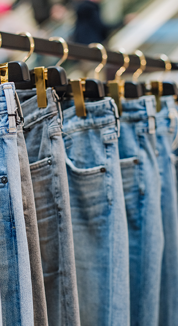 tylish jeans pants in a clothing store on the stands showcase with labels for the inscription