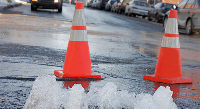 Close up on a flood caused by a frozen underground waterpipe in extreme cold day