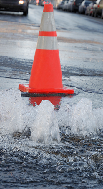 Close up on a flood caused by a frozen underground waterpipe in extreme cold day
