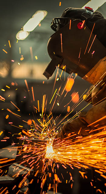 Metal worker using a grinder