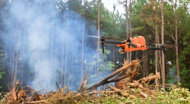 Ecological disaster as a result of a fire on the forest, fire services are using a drone to follow the fire into the trees fire
