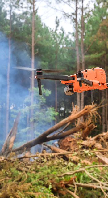 Ecological disaster as a result of a fire on the forest, fire services are using a drone to follow the fire into the trees fire