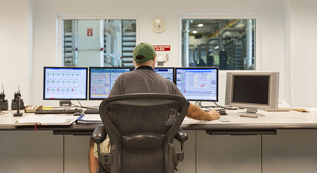 A technician oversees the control center for a public water utility company.